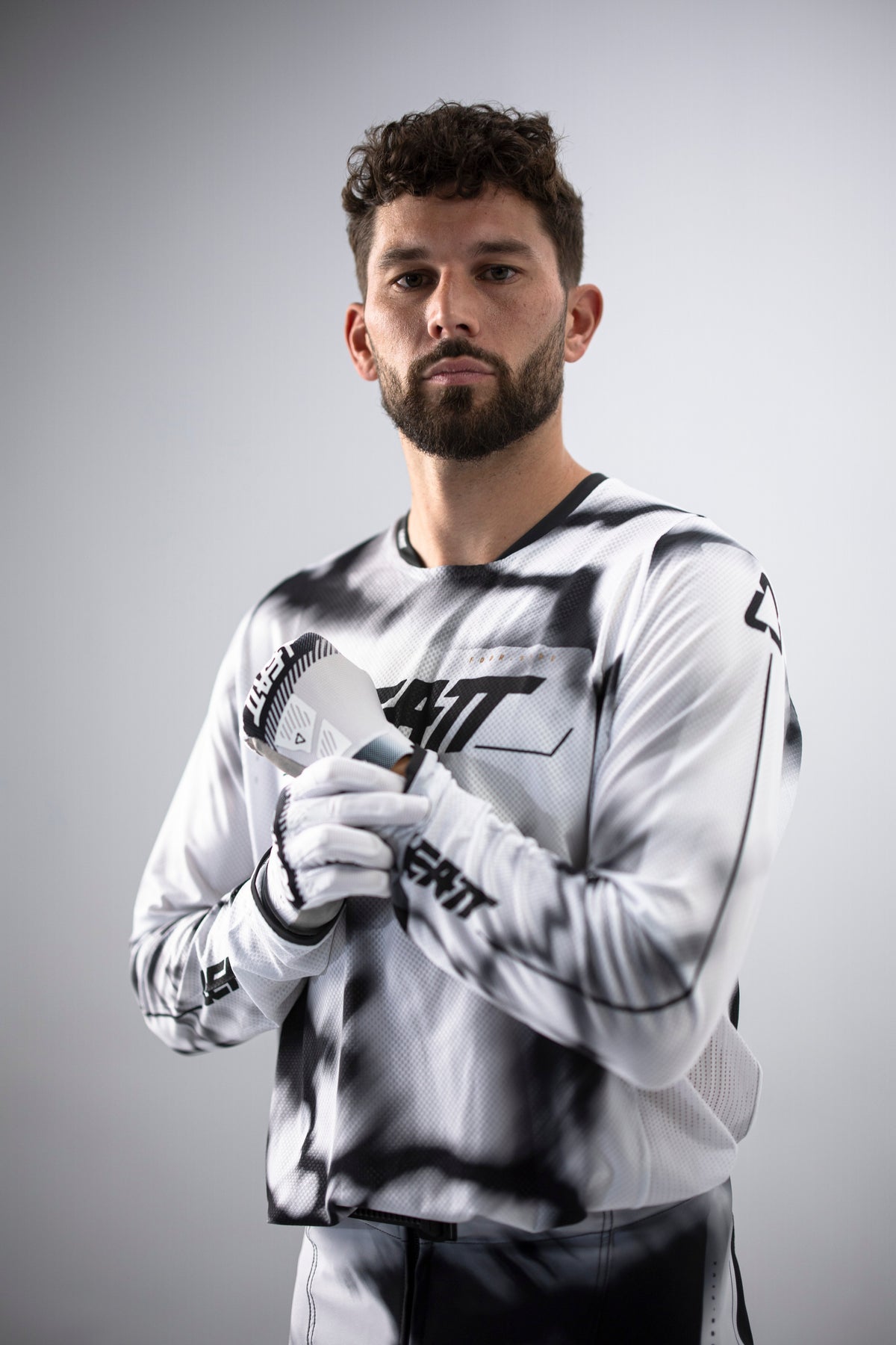 Colt Nichols wearing a white and black Leatt kit with gloves on a gray background
